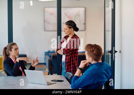 Ein Team erfolgreicher Programmierer sitzt in einem Startup-Büro, um neue Geschäftsprojekte zu planen, bestehende Herausforderungen zu lösen und Innovationen zu präsentieren Stockfoto