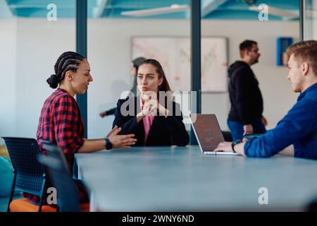 Ein Team erfolgreicher Programmierer sitzt in einem Startup-Büro, um neue Geschäftsprojekte zu planen, bestehende Herausforderungen zu lösen und Innovationen zu präsentieren Stockfoto