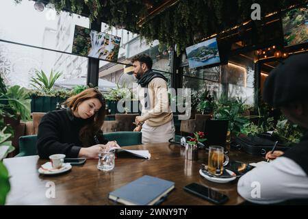 Jungunternehmer, die an einem Geschäftstreffen in einem modernen Café teilnahmen. Stockfoto