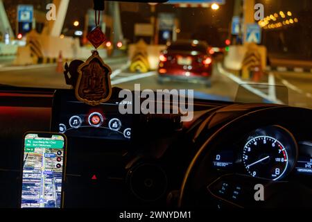 Nachtfahrten mit Routennavigation in einem Smartphone, das an einem Freisprechgerät befestigt ist Stockfoto