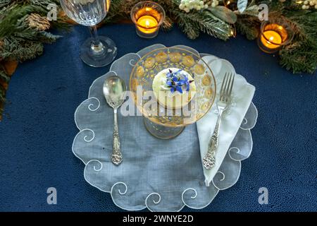 Käsekuchen-Dessert und Schlagsahne mit Goldstaub auf einer schicken Kristallglasschale mit Goldätzung. Stockfoto