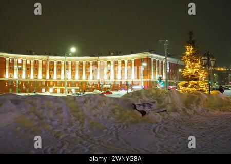 Petrosawodsk, Karelien, Russland, 01.13.2024: Gagarin-Platz, Blick auf die Leninallee, Weihnachtsbäume. Winterabend oder -Nacht, Schnee weht in der Nähe der Straße Stockfoto