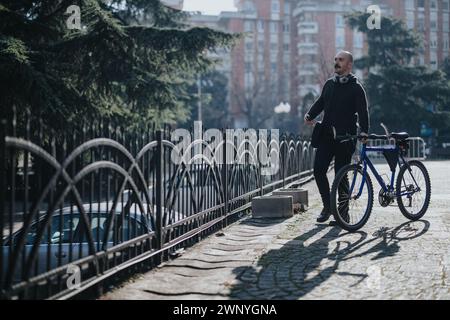 Lässiger Mann mit Fahrrad, der eine Pause im Stadtpark macht. Stockfoto