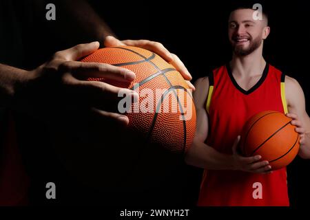 Basketballspieler mit Lederbälle auf schwarzem Hintergrund, Collage Stockfoto