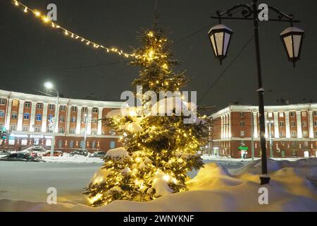 Petrosawodsk, Karelien, Russland, 01.13.2024: Gagarin-Platz, Blick auf die Leninallee, Weihnachtsbäume. Winterabend oder -Nacht, Schnee weht in der Nähe der Straße Stockfoto