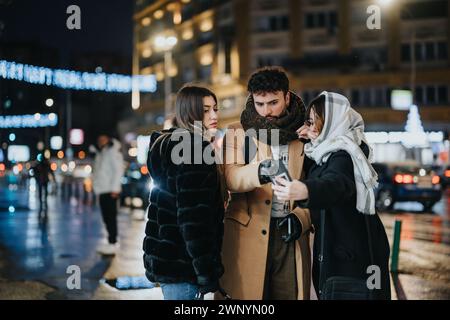 Gruppe junger Erwachsener, die nachts in urbaner Umgebung ein Smartphone benutzen. Stockfoto