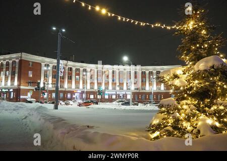 Petrosawodsk, Karelien, Russland, 01.13.2024: Gagarin-Platz, Blick auf die Leninallee, Weihnachtsbäume. Winterabend oder -Nacht, Schnee weht in der Nähe der Straße Stockfoto