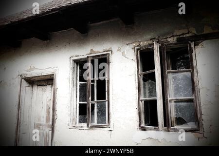 Verlassenes, gruseliges altes Haus. Holzfenster und -Türen. Die Hütte ist eine Schlammhütte. Samani Haus. Weißes Stuckpflaster. Halloween-Thema. Altern, Einsamkeit Stockfoto