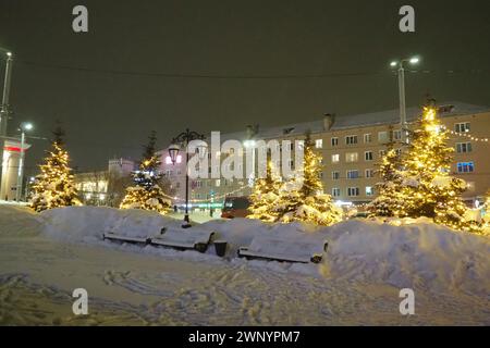 Petrosawodsk, Karelien, Russland, 01.13.2024: Gagarin-Platz, Blick auf die Leninallee, Weihnachtsbäume. Winterabend oder -Nacht, Schnee weht in der Nähe der Straße Stockfoto