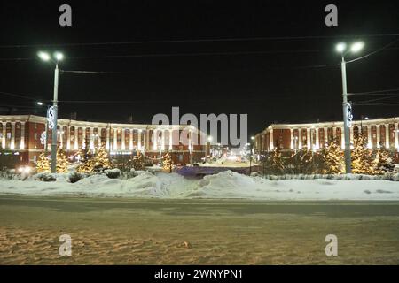 Petrosawodsk, Karelien, Russland, 01.13.2024: Gagarin-Platz, Blick auf die Leninallee, Weihnachtsbäume. Winterabend oder -Nacht, Schnee weht in der Nähe der Straße Stockfoto