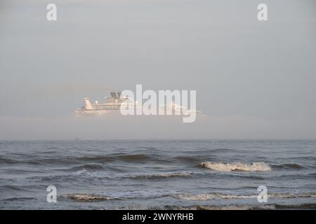 Kreuzfahrtschiff verlässt den Hafen von Galveston in einem Streifen des dichten Nebels Stockfoto