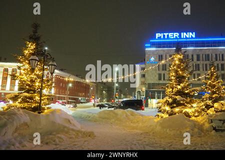 Petrosawodsk, Karelien, Russland, 01.13.2024: Gagarin-Platz, Blick auf die Leninallee, Weihnachtsbäume. Winterabend oder -Nacht, Schnee weht in der Nähe der Straße Stockfoto