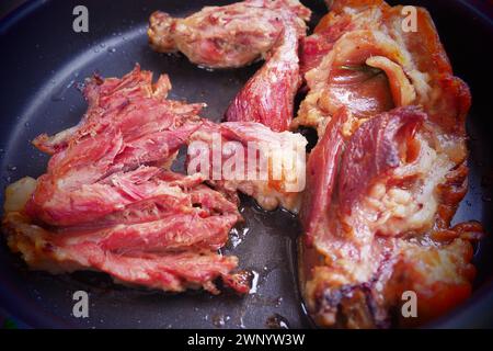 Geröstetes geräuchertes Schweinefleisch, Schulter oder Knie. Köstliches Fleisch auf einem schwarzen Backblech mit Tropfen Pflanzenöl, aus dem Ofen genommen. Schweinefleisch Delikatesse für Stockfoto