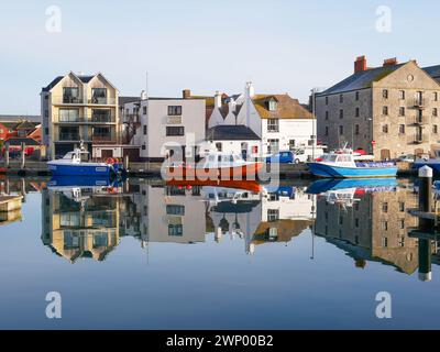 Fischerboote auf dem Fluss am Weymouth Harbour in Dorset, England mit alten Gebäuden am Hafen. Stockfoto