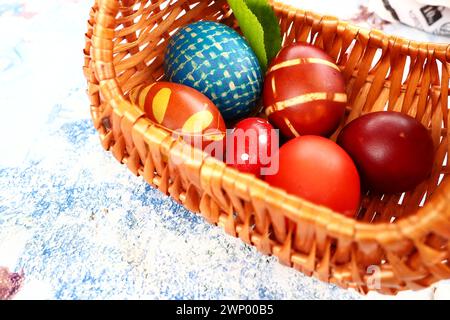 Ostereier in verschiedenen Farben, gefärbt mit Zwiebelschalen und Farbe in Korb. Gemüsemuster auf der Schale. Traditionelle festliche Farben Stockfoto