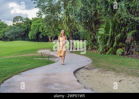 Ruhige Szene, in der eine schwangere Frau friedliche Momente im Park genießt, die Ruhe der Natur genießt und während ihrer Schwangerschaft Trost findet Stockfoto