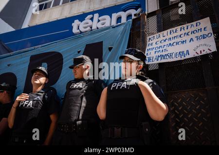 Buenos Aires, Argentinien. März 2024. Drei Polizisten bewachen den Eingang der Agentur während des Protestes. Protest und symbolische Umarmung der Nationalen Nachrichtenagentur Telam gegen die Ankündigung ihrer Schließung und Entlassung ihrer Pressearbeiter durch den Präsidenten der Nation, Javier Milei. Quelle: SOPA Images Limited/Alamy Live News Stockfoto