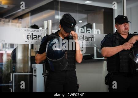 Buenos Aires, Argentinien. März 2024. Zwei Polizisten bewachen den Eingang der Agentur während des Protestes. Protest und symbolische Umarmung der Nationalen Nachrichtenagentur Telam gegen die Ankündigung ihrer Schließung und Entlassung ihrer Pressearbeiter durch den Präsidenten der Nation, Javier Milei. Quelle: SOPA Images Limited/Alamy Live News Stockfoto