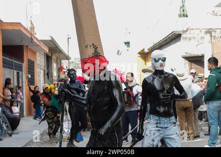 März 2024, San Nicolas de los Ranchos, Mexiko: Jugendliche mit schwarz lackiertem Körper und Masken nehmen an der vorspanischsprachigen Feier „der Karneval der Xinacates“ Teil, die in San Nicolas de los Ranchos, Gemeinde an den Hängen des Vulkans Popocatepetl, im Bundesstaat Puebla stattfindet. Als Teil der Tradition gehen die Xinacates oder gemalten Menschen auf die Straßen, um Touristen zu malen. Während dieser Feierlichkeiten wird dem Teoton-Vulkan Tribut gezollt, damit die Bewohner eine gute Erntezeit haben. Am 3. März 2024 in San Nicolas de los Ranchos, Mexiko. (Foto von es Stockfoto