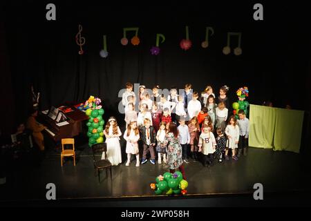 Sremska Mitrovica, Serbien 8. März 2022 Kinderchoraufführung auf der Bühne. Kinder singen. Musikalische Kindergruppe in eleganten Kostümen Stockfoto