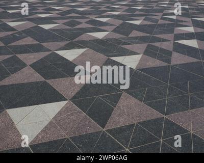Das Quadrat ist mit dreieckigen Fliesen gepflastert. Graue, weiße, schwarze Fliesen auf der Straße. Die Kopfsteinoberfläche. Modernes Design von Straßen, Straßen, Plätzen Stockfoto