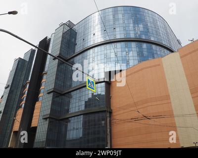 Der Himmel und die Glasfassade des Gebäudes. Reflexion des Himmels und der Wolken auf der Glaswand. Wolkenkratzer in der Stadt. Moderne Glasgebäude und Stockfoto