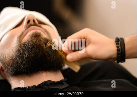 Friseurkämme Bart mit Kamm beim Schneiden und Rasieren des Kaukasiers Stockfoto