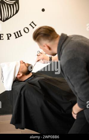 Friseurkämme Bart mit Kamm beim Schneiden und Rasieren des Kaukasiers Stockfoto