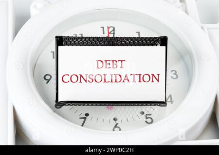 Schuldenkonsolidierung. Dies ist der Prozess, um ein neues Darlehen zur Rückzahlung einer Reihe bestehender Schulden zu erhalten. Der Text steht auf einer weißen Visitenkarte Stockfoto