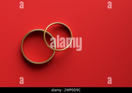 Goldene Eheringe auf rotem Hintergrund. Ehe, Verlobung, Liebe und Romantik. 3D-Rendering. Stockfoto