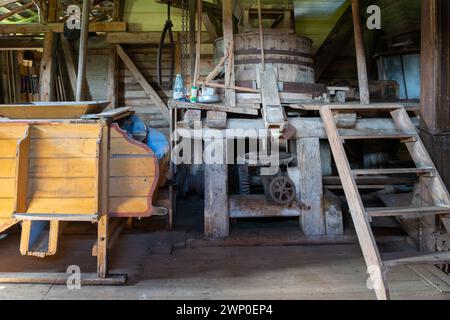 Das Innere einer alten Wassermühle. Alte Maschinen einer verlassenen Mühlenfabrik von innen. Stockfoto