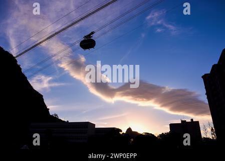 Silhouetten der Zuckerhut-Seilbahn und des Berges Corcovado von Praia Vermelha bei Sonnenuntergang - Urca, Rio de Janeiro, Brasilien Stockfoto