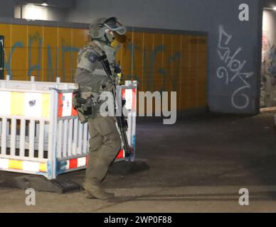 04. März 2024, Berlin: Ein Polizeibeamter mit Spezialausrüstung verlässt ein Hochhaus in Berlin-Friedrichshain. Die Suche nach den beiden ehemaligen RAF-Terroristen Garweg und Staub hat erneut zu einem größeren Polizeieinsatz durch eine niedersächsische Sondereinsatzgruppe in Berlin-Friedrichshain geführt. Eine Sprecherin des Niedersächsischen Landeskriminalamtes, das für die Operation zuständig war, sagte am Dienstag (05.03.2024), dass es Hinweise auf ein Objekt gegeben habe und Beamte eine Wohnung in einem Studentenwohnheim durchsucht hätten. Foto: Dominik Totaro/dpa Stockfoto