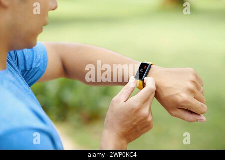 Nahaufnahme eines Joggers, der die Herzfrequenz auf Fitness-Tracker überprüft Stockfoto