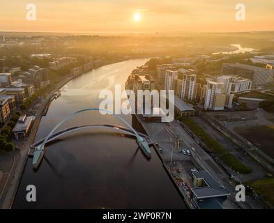 Blick aus der Vogelperspektive nach Osten, während die Sonne an einem nebeligen Herbstmorgen über der Millennium Bride in Newcastle aufgeht Stockfoto