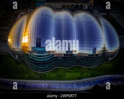 Spektakulärer, abstrakter Blick auf das sage Centre Gateshead, das sich direkt nach unten öffnet. Die aufgehende Sonne wird im Glas wiederbelebt Stockfoto