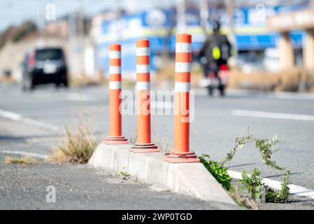 Orangefarbene Kunststoff-Verkehrs- und Absperrpfosten am Straßenrand. Stockfoto