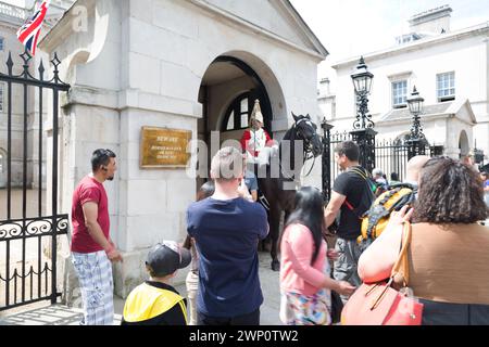 Großbritannien, London, ein berittenes Mitglied des Royal Horse Guards Regiments, das vor Horse Guards Whitehall im Wachdienst steht, Touristen fotografieren. Stockfoto