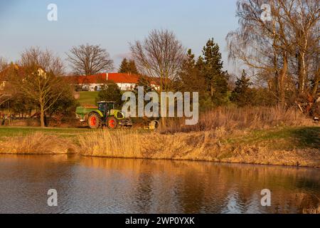 Traktor am Ufer des Teichs. Stockfoto