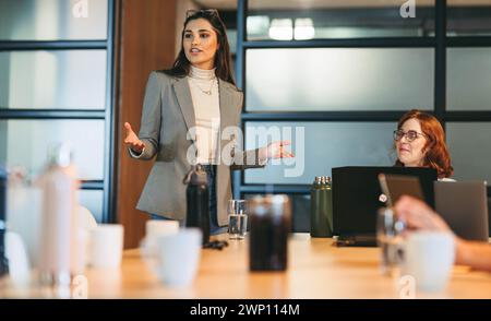 Eine Gruppe von Fachleuten arbeitet in einem modernen Sitzungssaal zusammen. Unter der Leitung eines Teamleiters diskutieren sie Ideen für ein neues Projekt in dynamischer und c Stockfoto