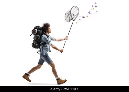 Profilaufnahme eines jungen Mannes mit einem Rucksack, der Schmetterlingen mit einem Fangnetz auf weißem Hintergrund hinterherläuft Stockfoto