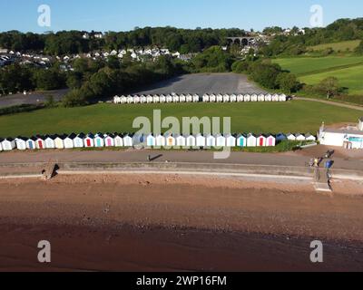 Drohnenfoto von einem Sandstrand am Meer mit einer Reihe von Strandhütten an einem beliebten Urlaubsziel Paignton in Devon Stockfoto