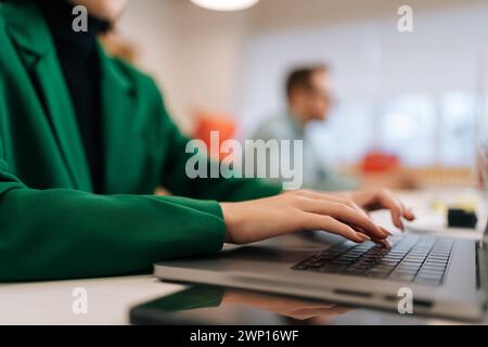 Nahaufnahme der Hände einer nicht erkennbaren Programmiererin, die beim Coworking Programmcode auf der Laptop-Tastatur eingibt. Nahaufnahme eines jungen Texters, der Text schreibt Stockfoto