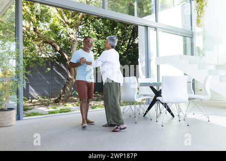 Senioren-Biracial-Paar in lässiger Kleidung unterhalten sich im Freien Stockfoto