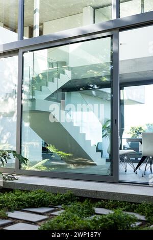 Eine moderne Treppe ist durch das große Glasfenster eines modernen Hauses sichtbar Stockfoto