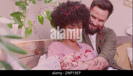 Das Bild von Herzen über glückliche, vielfältige Paare, die sich umarmen Stockfoto