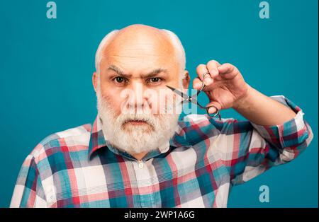 Porträt von stilvollen Mann bärtigen Mann mit grauen Schnurrbart Bart halten Barbier Schere. Bärtiger Mann, bärtiger Mann. Stockfoto