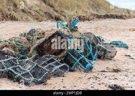 Alte Hummer-Töpfe / Creels und Fischernetze stapelten sich an einem North Berwick Beach Stockfoto