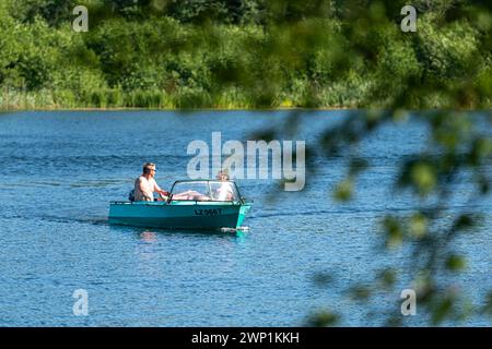 Aluksne, Lettland - 19. Juni 2021: Menschen in einem kleinen Boot auf dem Aluksne-See Stockfoto