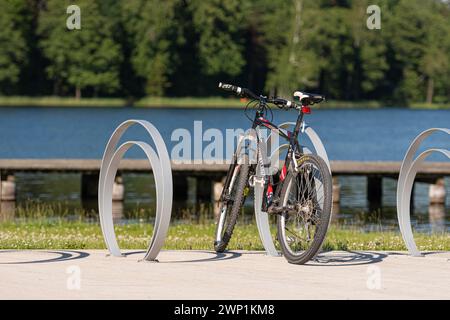 Aluksne, Lettland - 19. Juni 2021: Fahrrad parkt im Sommer an der Promenade in der Nähe des Sees Stockfoto